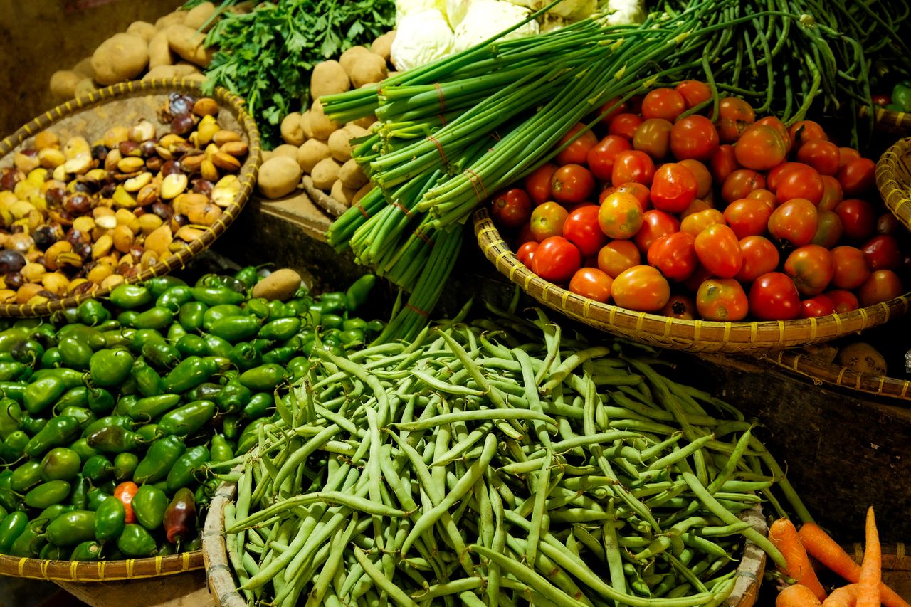 Colorful assortment of fresh vegetables in a local market setting.